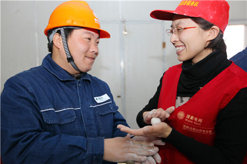 电力志愿者刘常鸿（右）与进城务工人员叶敏（左）一起做元宵.jpg
